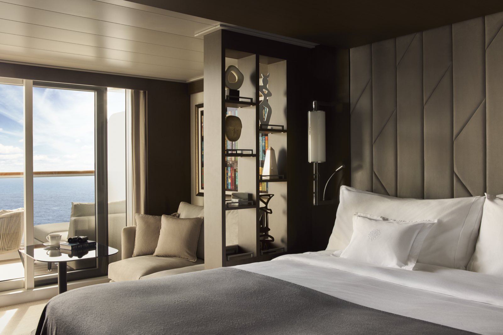 Ocean Terrace Suite auf einem Explora-Schiff: Bett, Sitzecke und bodentiefe Fenster zur eigenen Terrasse mit Meerblick