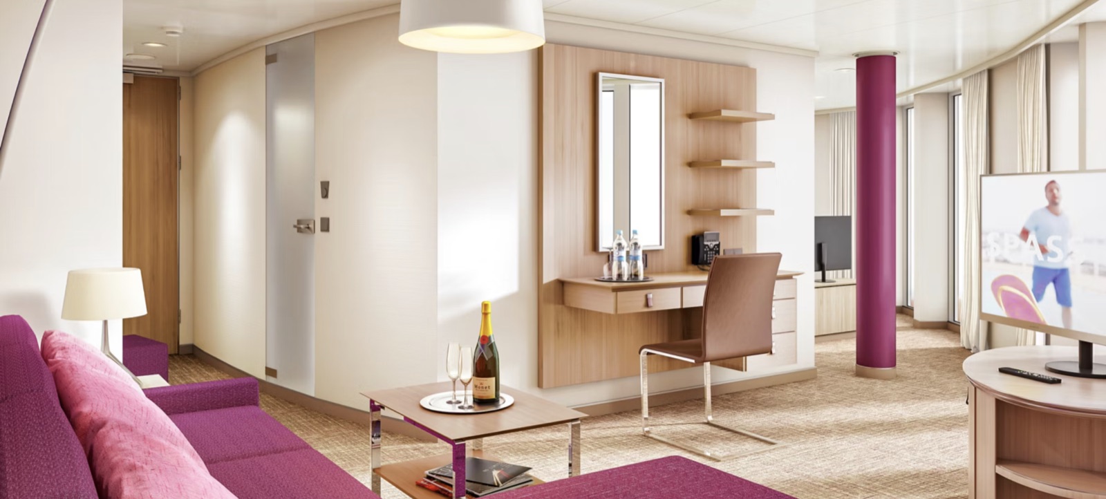 Wohnbereich einer AIDA Suite mit Sofa, Schreibtisch und Sekt auf dem Tisch
