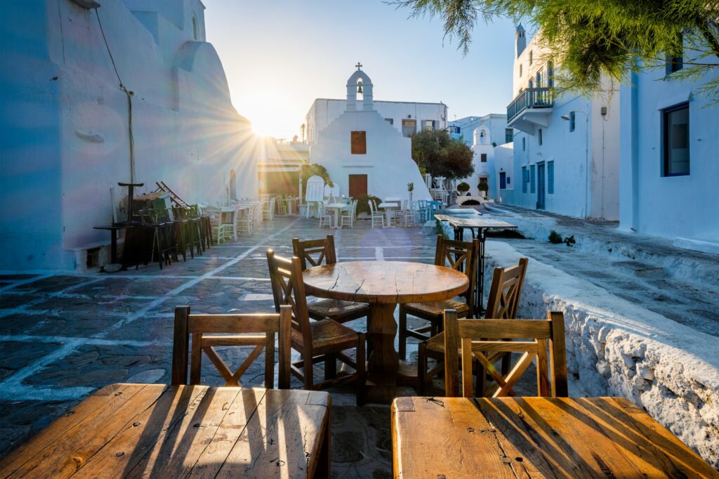 Cafe table in picturesque streets of Mykonos Chora town in famous tourist Mykonos island, Greece