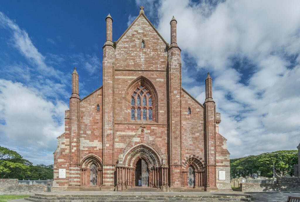 Exterior of St Magnus Cathedral, ornate red sandstone church.