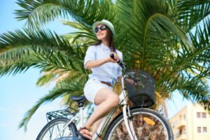 Young woman riding city bicycle near sea