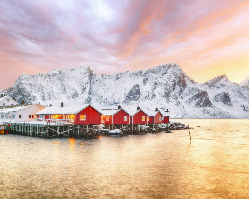 Traditional Norwegian red wooden houses (rorbuer) on the shore of Reinefjorden near Hamnoy village